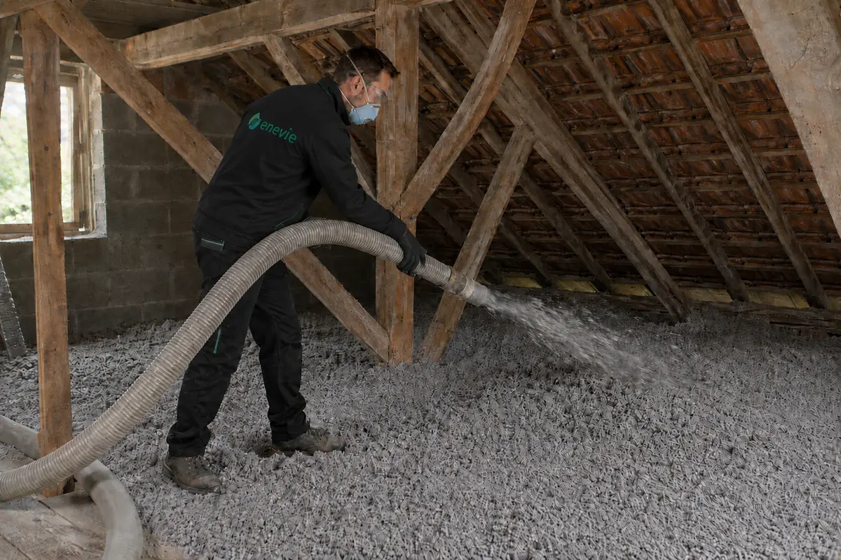 Technicien Enevie soufflant l’isolant dans des combles perdus